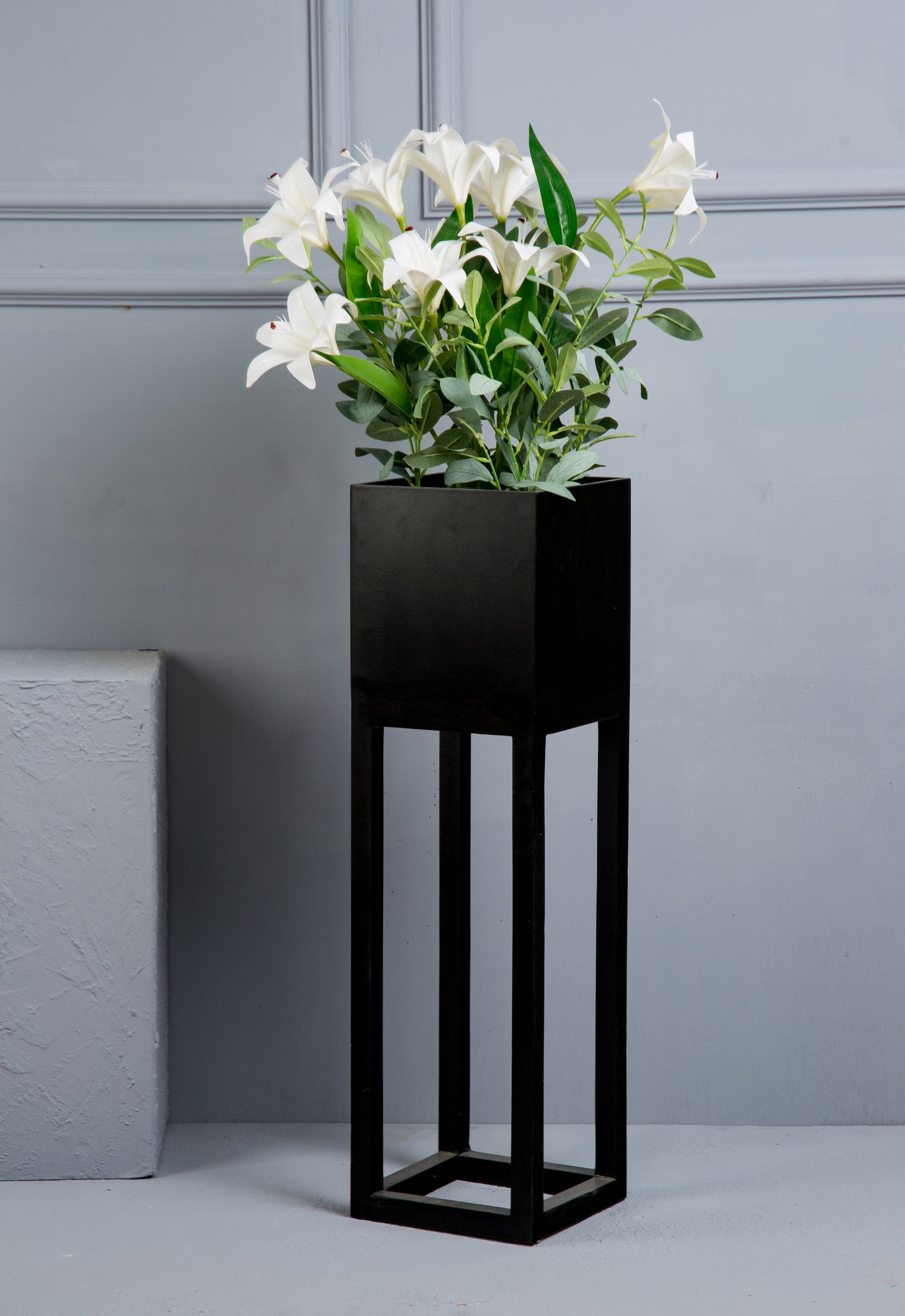 Black cube with lilium plant